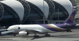 Kanadai férfi kinyitja a Thai Airways járatának ajtaját felszállás előtt